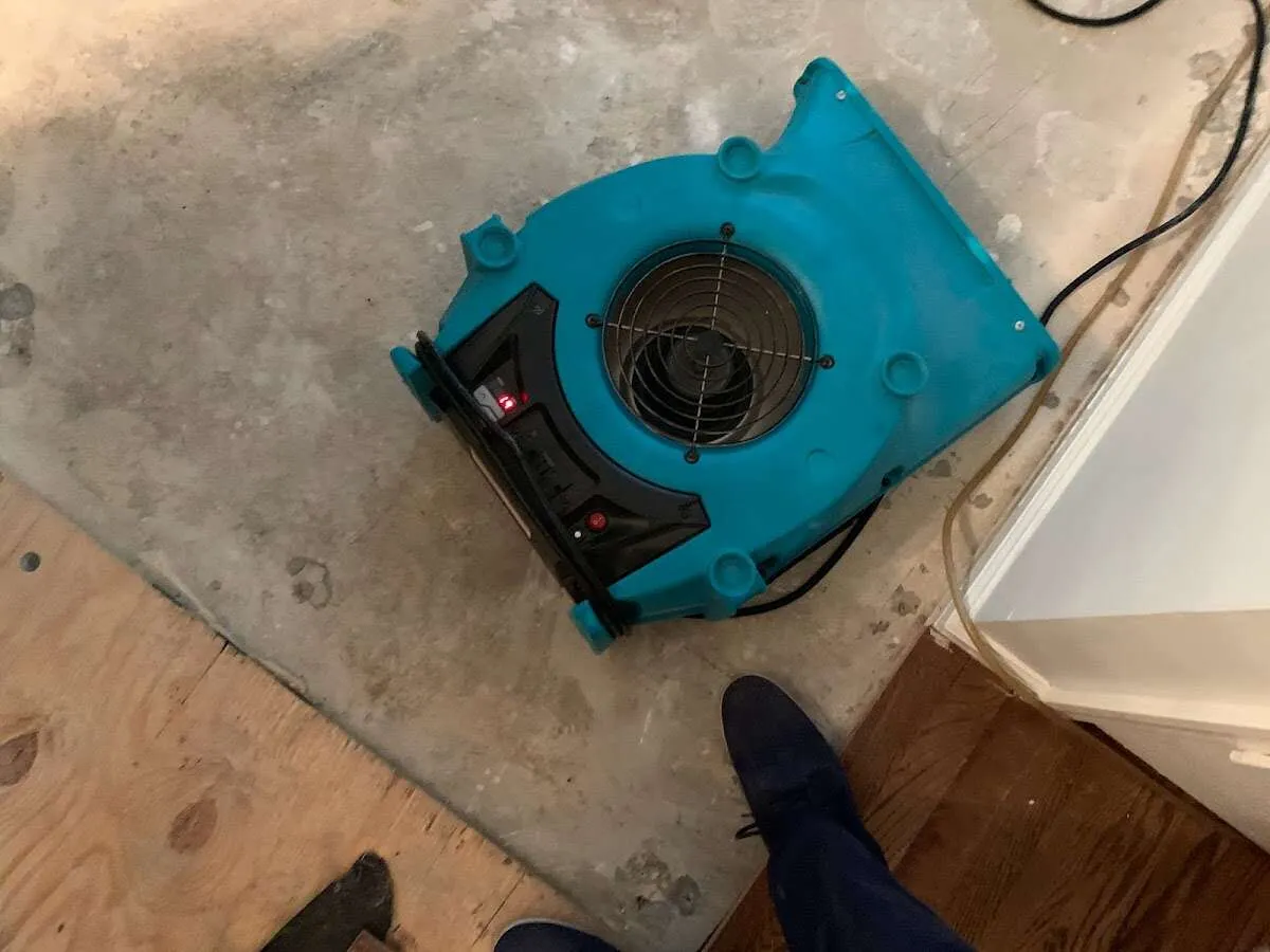 Air mover drying subfloor during Commercial Water Damage Restoration in Conover